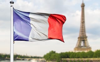 10 Biotechnology Companies in France to Know A French flag waves in the air with the Eiffel Tower in the background.