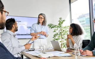 Team members chat in a boardroom while going through the results of a recent project.
