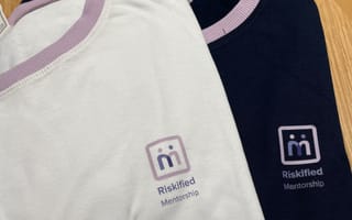 An image of two Riskified Mentorship T-shirts laid out on a table