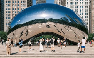 Tourists take photos of the Bean in Chicago’s Millennium Park on a summer day