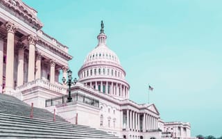 Front facade of Capitol building with light blue background.