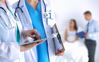 Healthcare professionals wearing white coats and stethoscopes are pictured.