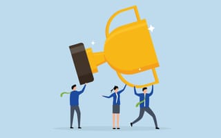 An illustration of three professionals raising a giant trophy above their heads, symbolizing the idea of working together to achieve success