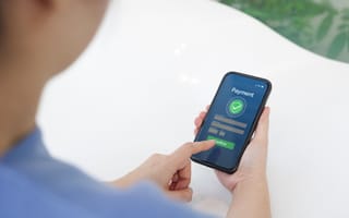 A person is holding a smartphone displaying a payment confirmation screen.