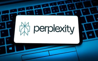 Perplexity logo featured on a mobile device sitting on top of a laptop keyboard.