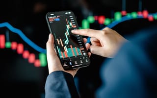 Photo of person tapping on mobile phone to view stocks.
