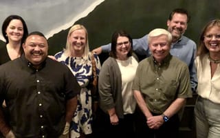 Vice President of Customer Experience Megan Fehn poses for a group photo with several of her colleagues