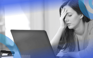 A young woman looks at a laptop with frustration.