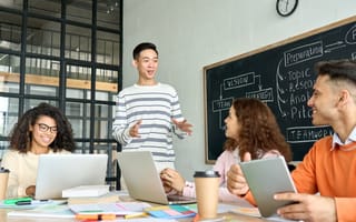 Four interns discuss an ongoing project while working together in an office conference room