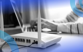 A picture of a cable modem next to a laptop.
