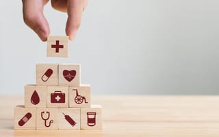 Blocks featuring medical icons like a stethoscope and bandage are stacked.