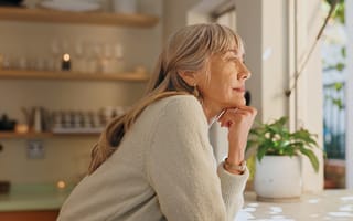 An older woman looks out a window.