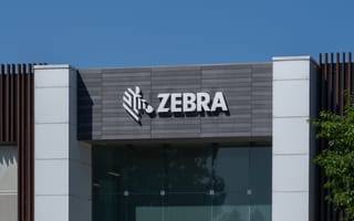 Facade of a modern building with the "Zebra" logo and name prominently displayed on a gray panel under a clear blue sky, creating a professional tone.