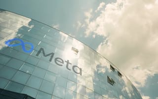 Reflective glass building with Meta logo under a partly cloudy sky. The structure conveys modernity and innovation, with a serene and bright ambiance.