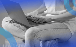 A software engineer works with a laptop on their lap