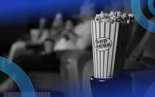 A popcorn container in a movie theatre with patrons in the background