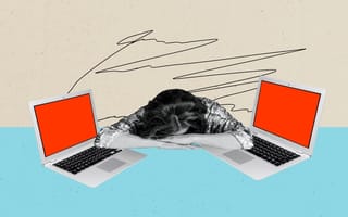 A burned-out worker lays their head between two laptops.