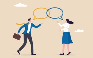 An illustration of a businesswoman and businessman chatting together while speech bubbles hover overhead, representing the idea of exchanging feedback in the workplace