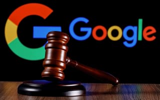 A judge's gavel rests on a table, with Google's logo displayed on a black background.
