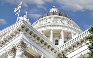 Three flags fly outside the California State Capitol.