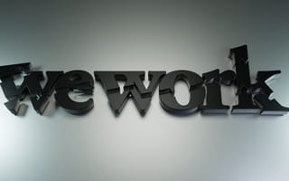 WeWork India to Launch ₹3,000 Crore IPO After Regulatory Approval 3D text spells "we work" in shiny black, fragmented font. The letters are cracked and jagged, conveying a sense of chaos against a gray background.