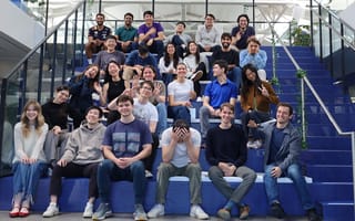 Exa's team is pictured sitting on stairs.
