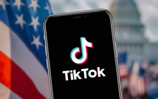A smartphone with TikTok on it against the backdrop with the U.S. Capitol and American flags.