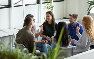 Six team members discuss an ongoing project while working together in an office