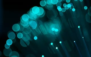 Blurred teal circular lights resembling bokeh effect over a dark background, conveying a serene, futuristic atmosphere with abstract aesthetics.