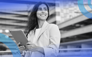 A woman holds a tablet with a confident look