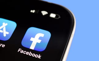 Image of the Facebook app logo in the top-right corner in the screen of a mobile phone.