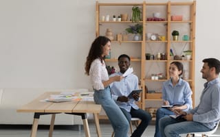 Four team members discuss a new sales strategy while working together in an office