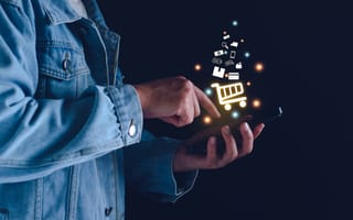 Livestream Marketplace Whatnot Raises $225M at $11.5B Valuation One hand holds a mobile device, while another hand interacts with the screens. Shopping carts, credit cards and other digital icons hover over the phone to represent online shopping.