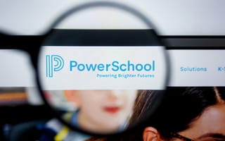 A magnifying glass focuses on the PowerSchool website header. The logo and tagline "Powering Brighter Futures" are visible, conveying a sense of education and innovation.