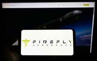 A smartphone displays the "Firefly Aerospace" logo in bold text with a stylized green emblem. In the blurred background, a rocket is shown against a dark sky, suggesting space exploration.