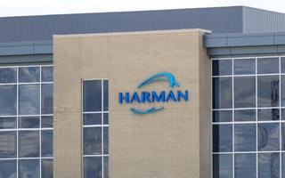 HARMAN Invests ₹345 Crore to Expand Pune Automotive Electronics Facility Exterior of a modern building with large windows. The "HARMAN" logo is displayed prominently in blue letters on a beige brick facade.