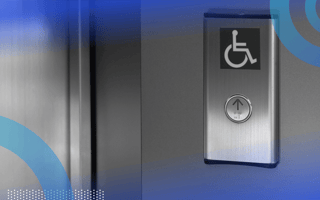 A silver elevator button with the accessibility symbol above it