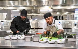 Two Sifted chefs prepare a meal for employees in a kitchen