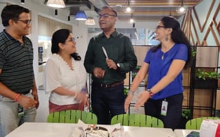 A group of ServiceNow employees talking in an office kitchen.