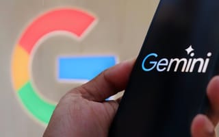 A hand holds a smartphone with the Gemini logo on the screen, and a multi-colored G representing the Google brand is in the background of the image.