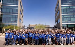Several colleagues chatting together over coffees in the office while working on a project