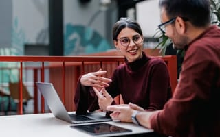 An intern chats with her colleague while working on an assignment in the office