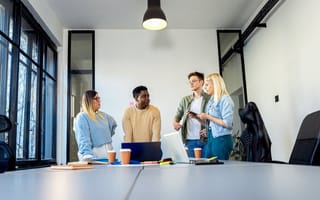Four team members discussing ideas for a project together in the office