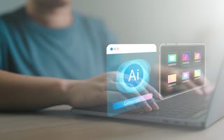 A person typing on a laptop with holographic AI and app icons appearing above the keyboard, suggesting futuristic technology use in a calm setting.