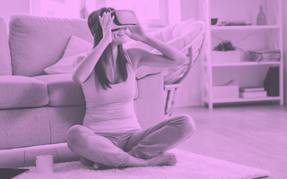 A person sitting on the floor wearing a VR helmet.