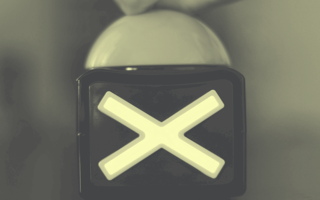 Closeup of a buzzer with a large "X" on it.