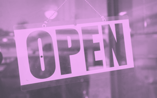 An open sign hanging in a window