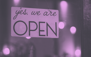 Storefront with an "yes, we are open" sign.