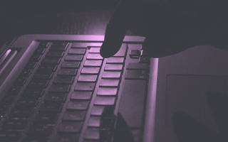 Shadowy hand typing on keyboard.