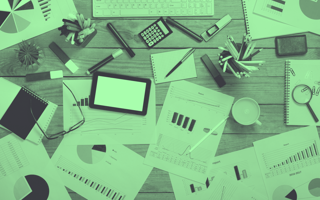 A table covered with research, papers, supplies.